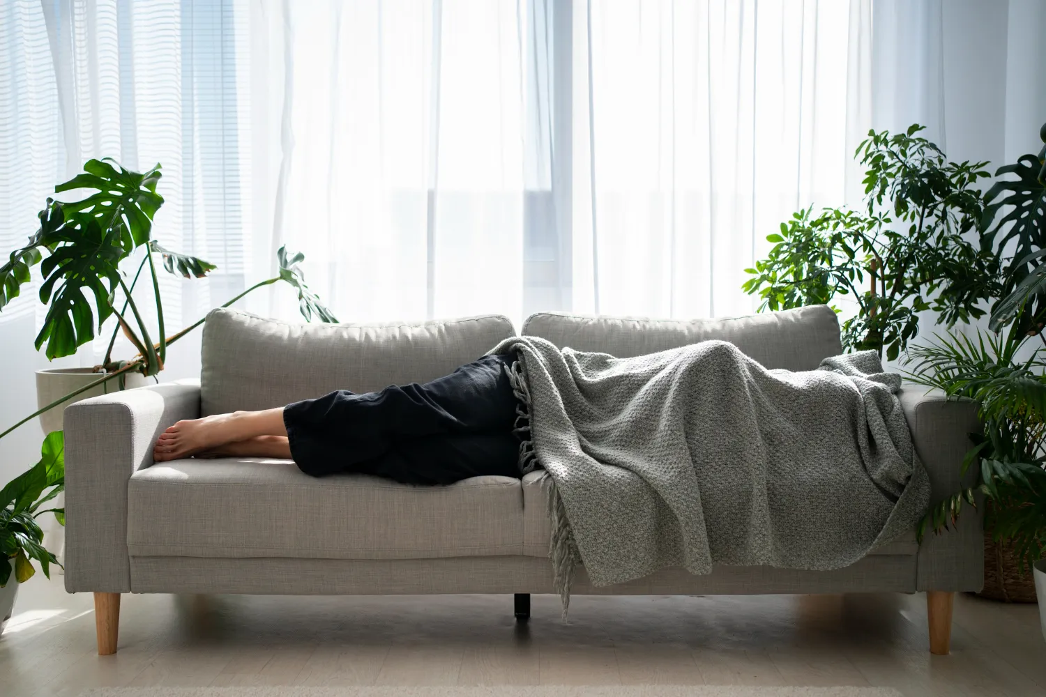 Frau sitzt entspannt auf einem Sofa und liest im Abendlicht