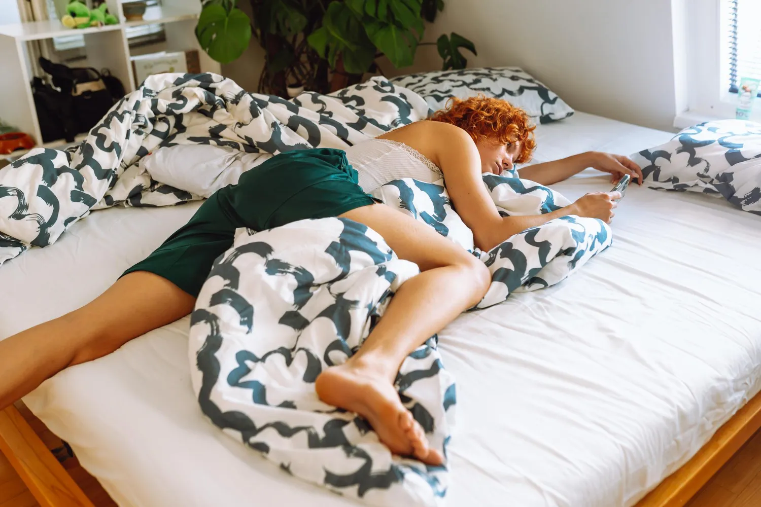Ungemachtes Bett mit heller Leinenbettwäsche im Morgenlicht